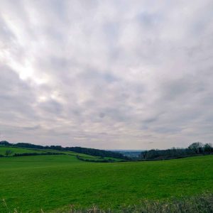 View of open fields with cloudy sky