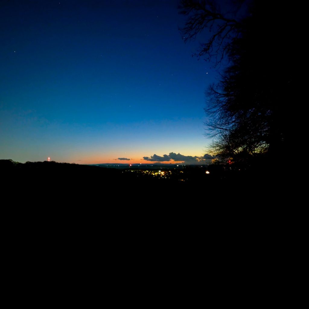 Evening starry sky with lights from houses in the distance